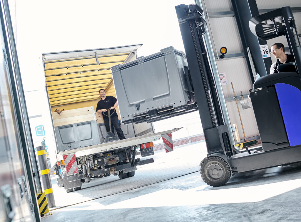 EMS Mitarbeiter beladen einen LKW mit Messestandteilen