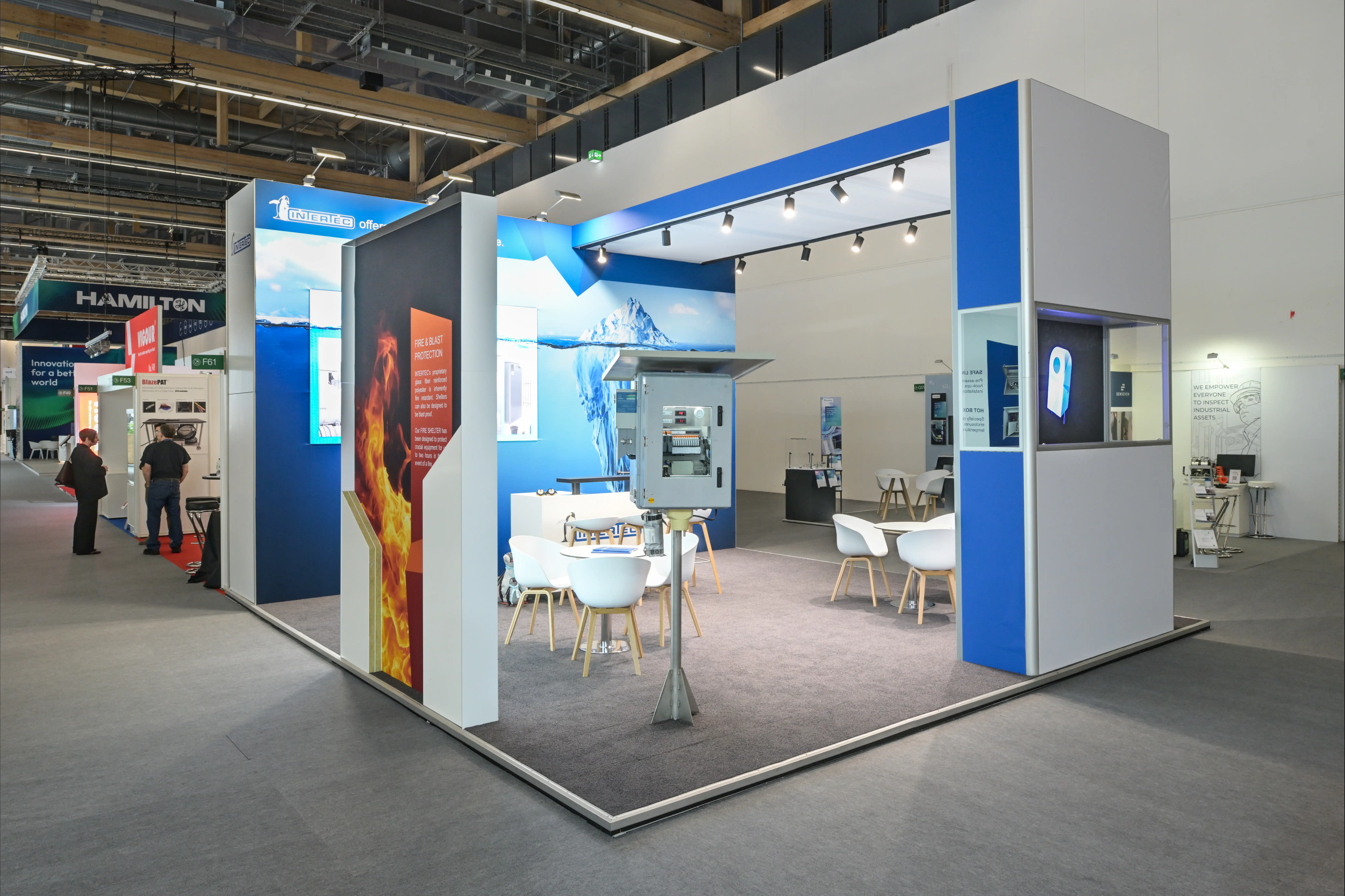 Beleuchteter Messestand von EMS mit weißen und blauen Akzenten