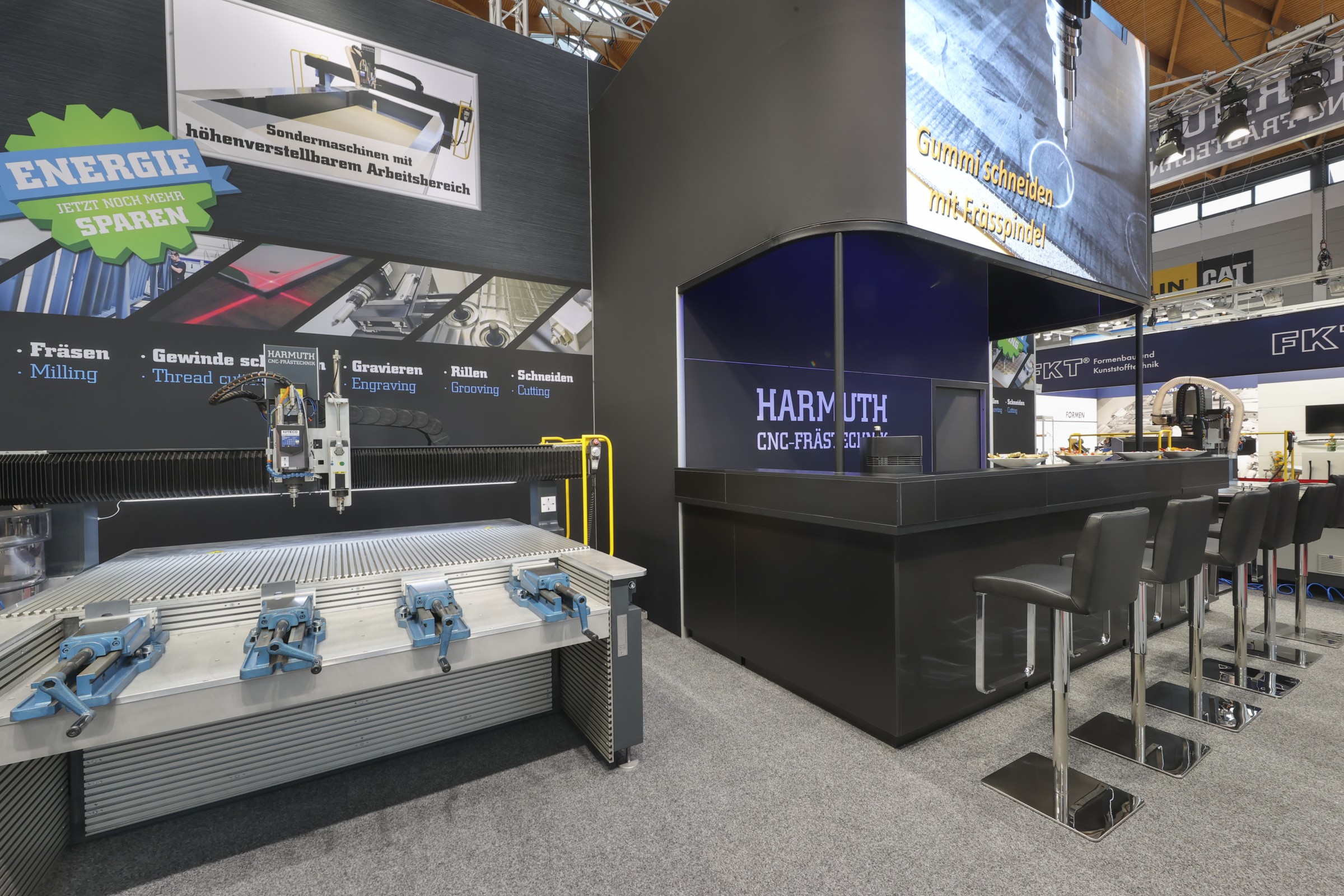 Messestand von Harmuth mit großem CNC-Frästisch und Maschinenmodellen.