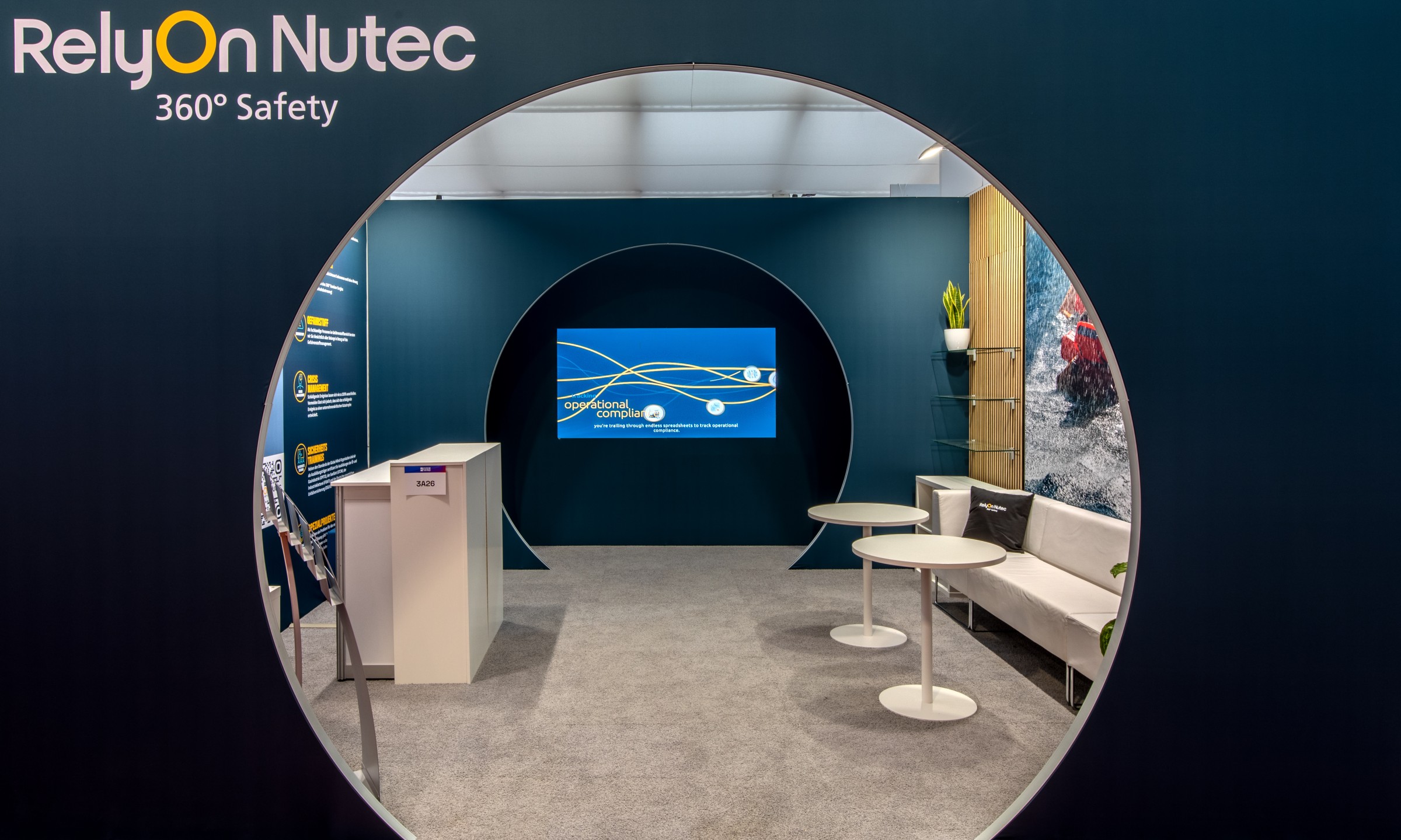 Messestand von RelyOn Nutec mit rundem Eingangsbereich, großem Monitor und modernen Sitzgelegenheiten