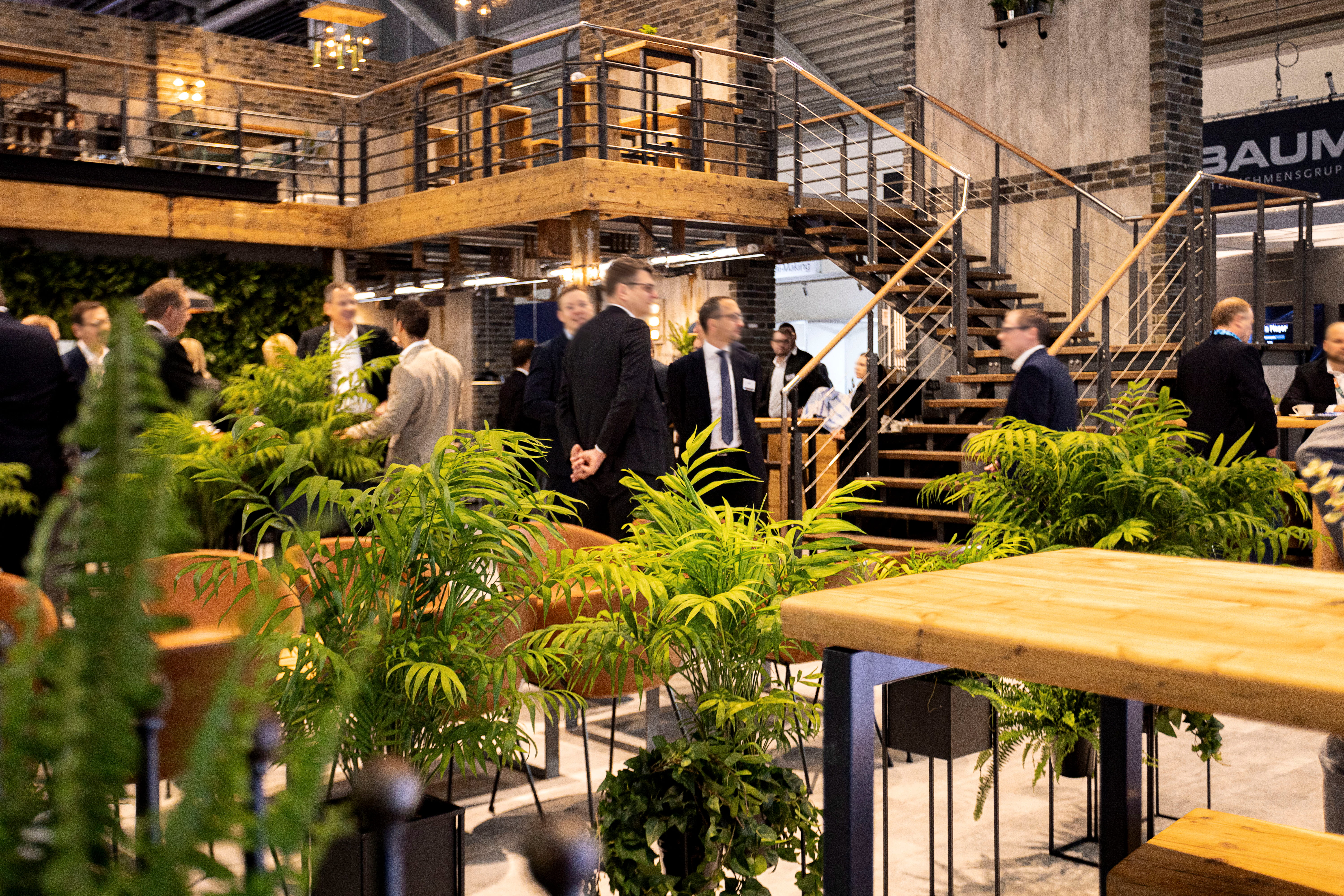 Messebesucher an einem nachhaltigen Edeka-Messestand mit Pflanzen