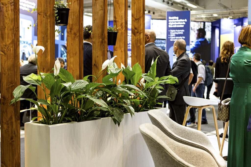 Messestand mit vertikalen Holzlamellen und integrierten Pflanzen