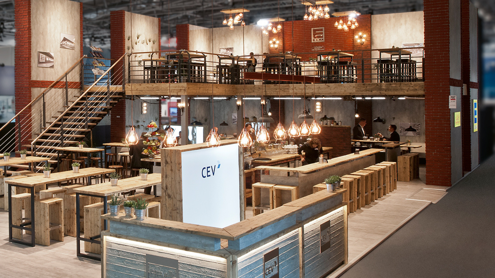 Moderner zweistöckiger Messestand mit Treppe, Sitzbereichen und Bar – Beispiel für mehr Raum und Sichtbarkeit auf Messen.