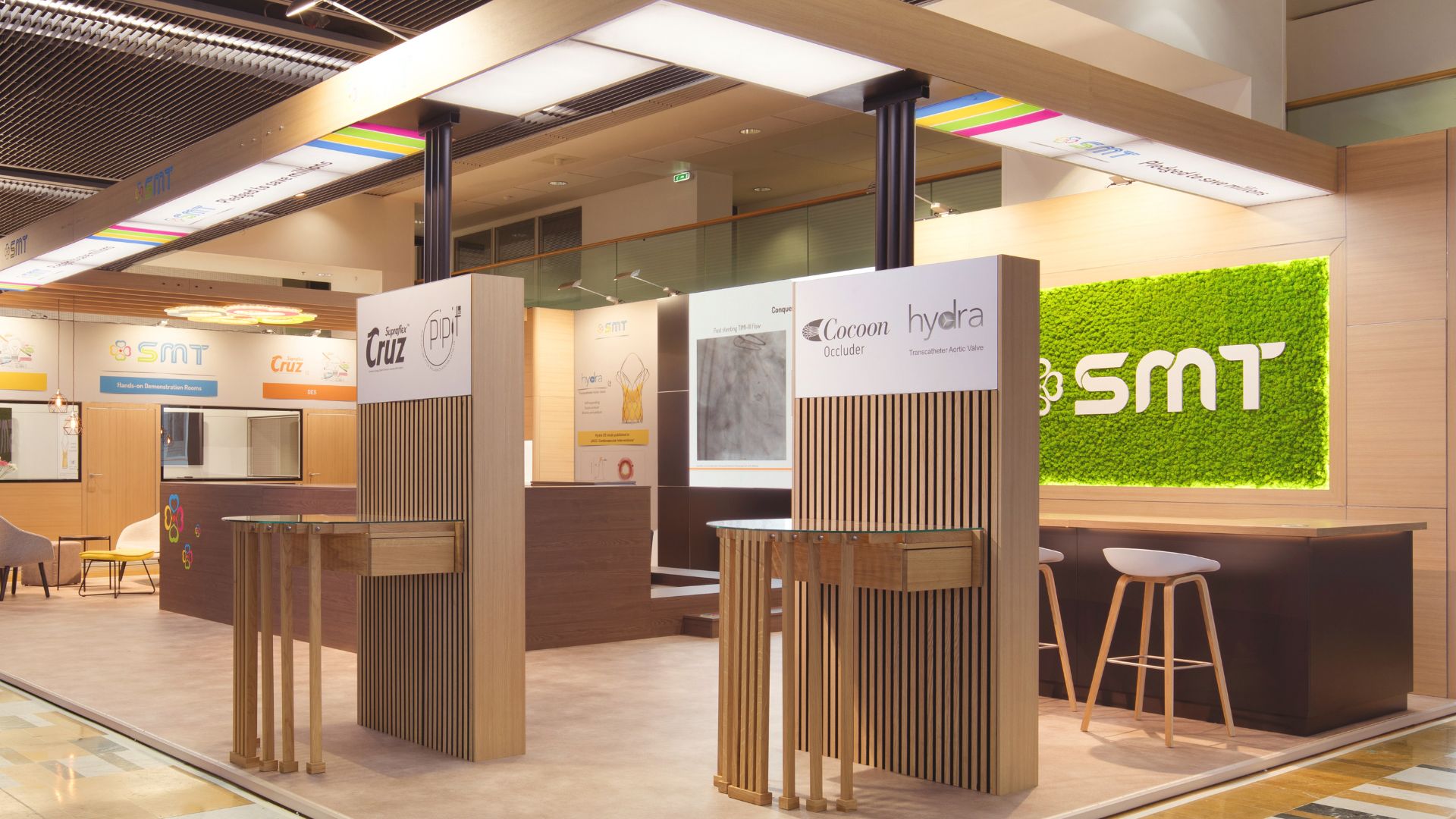 Moderner Messestand mit Holzmaterialien, klaren Linien und grüner Pflanzenwand